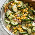Bowl of Mexican cucumber salad with sweet corn, lime, and chili, served fresh with cilantro and red onion